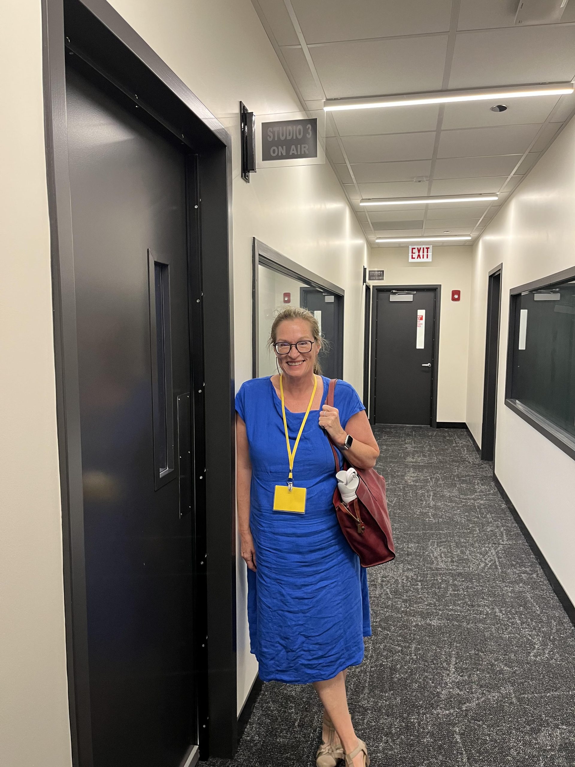 Attorney Coleman in a blue dress outside the WBEZ recording studio